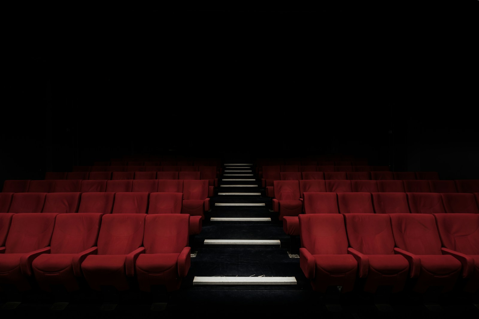 A premium cinematic concert stage with vibrant lighting beams